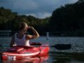 woman looking at the trees while riding on kayak